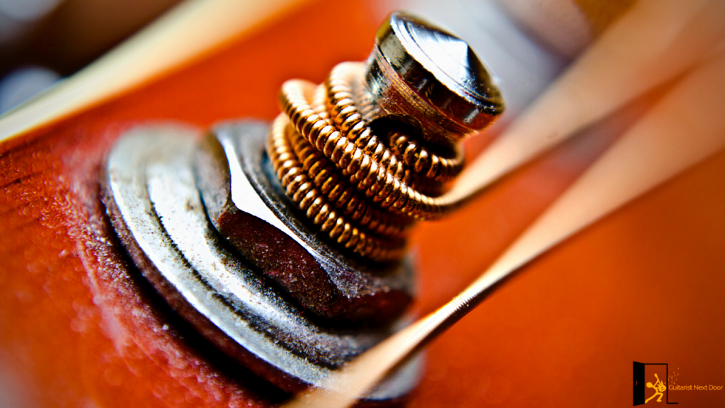 displays guitar strings and part of a guitar tuning machine