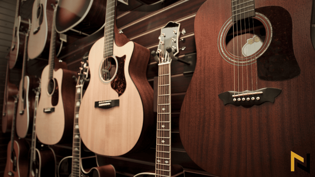 image showing concert vs dreadnought acoustic guitars hanging on a wall